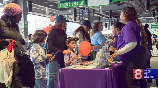 Families and children gather at an information booth during Angel of Edgewood’s Back-to-School Extravaganza, receiving supplies and speaking with volunteers.